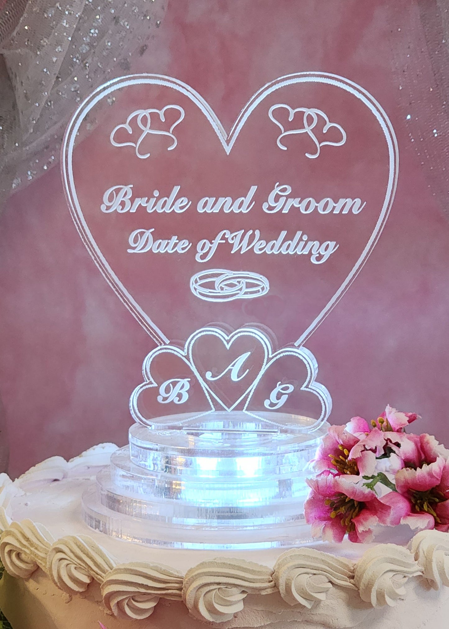 acrylic heart shaped cake topper lighted with a white LED, designed with hearts and engraved with names and date of wedding