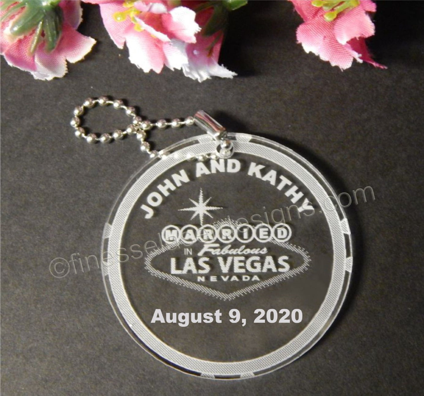 Acrylic keychain favor designed with Married in Las Vegas sign inside a poker chip along with names and date