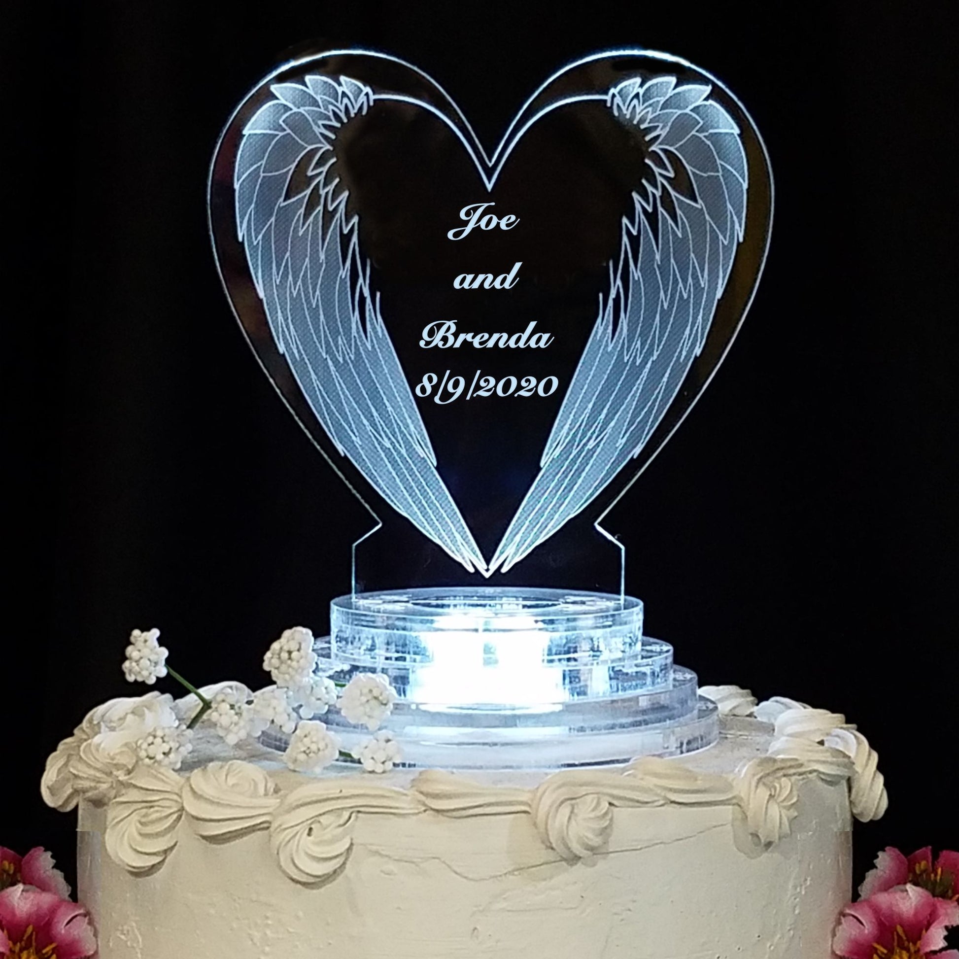 heart shaped acrylic cake topper designed with a downward angel wing and engraved with names and date