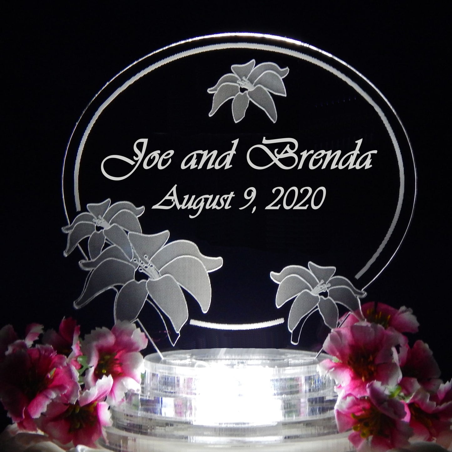 clear acrylic cake topper designed in a lily flower theme engraved with names and date