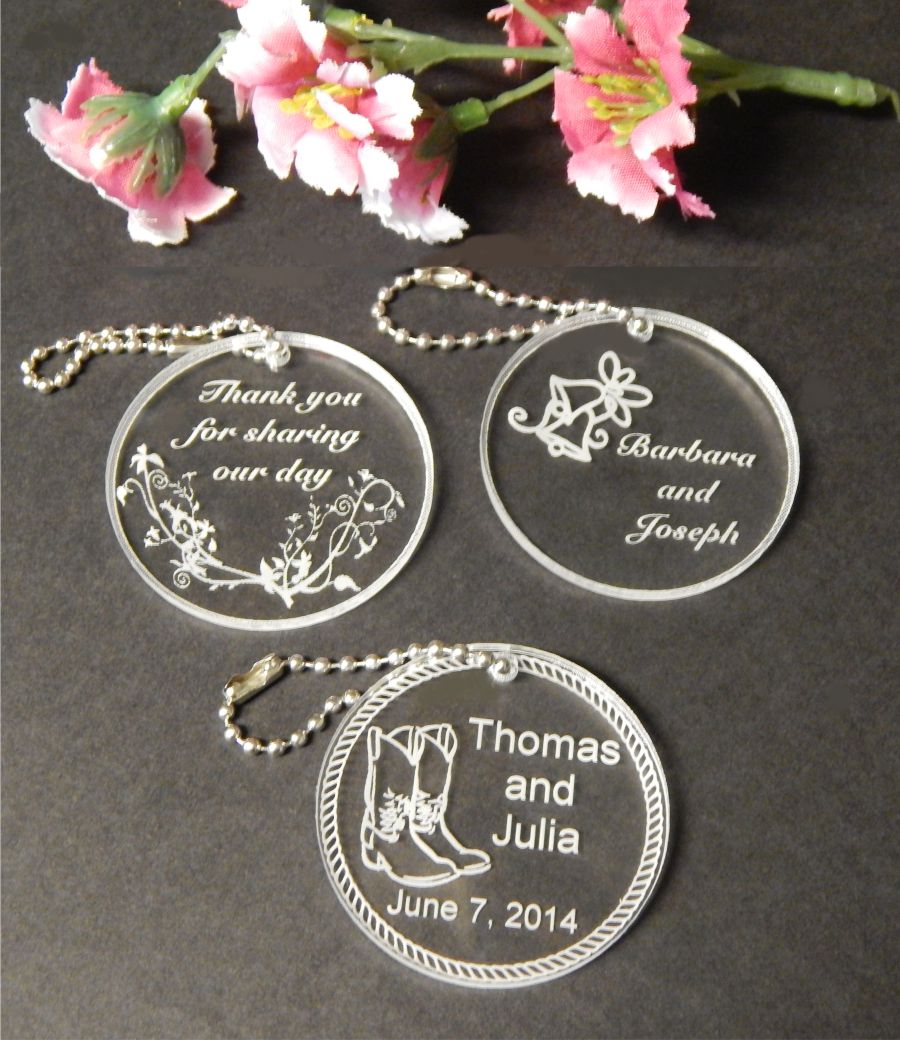 Three round acrylic keychain favors with assorted designs, small chain attached to each 