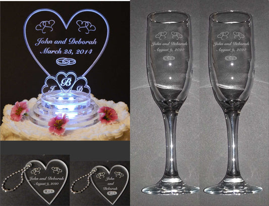 photo showing clear acyrlic heart shaped cake topper, large and small keychains, and set of two champagne flutes as a package 