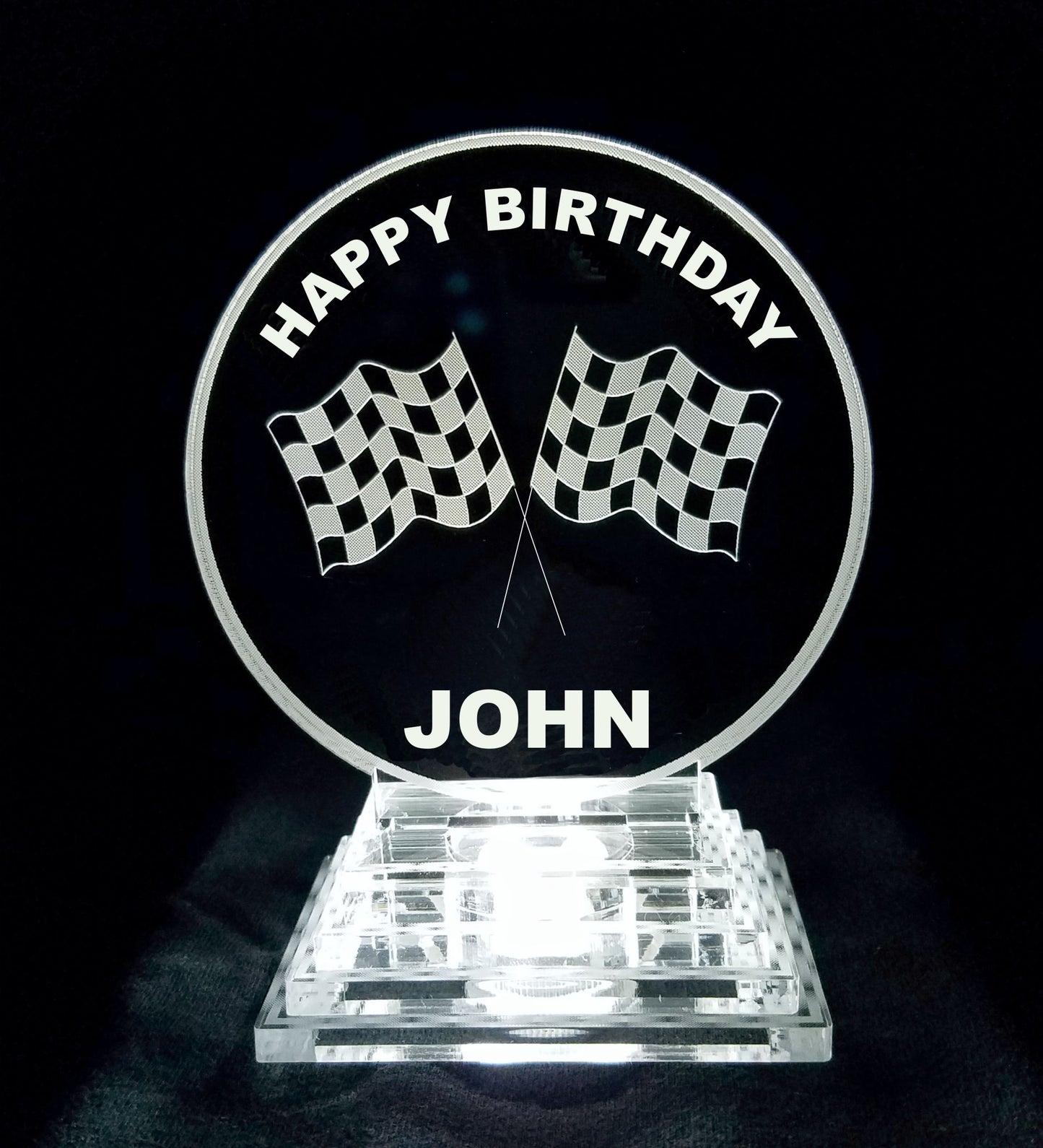 acrylic round cake topper designed with a pair of racing flags, Happy Birthday and a name
