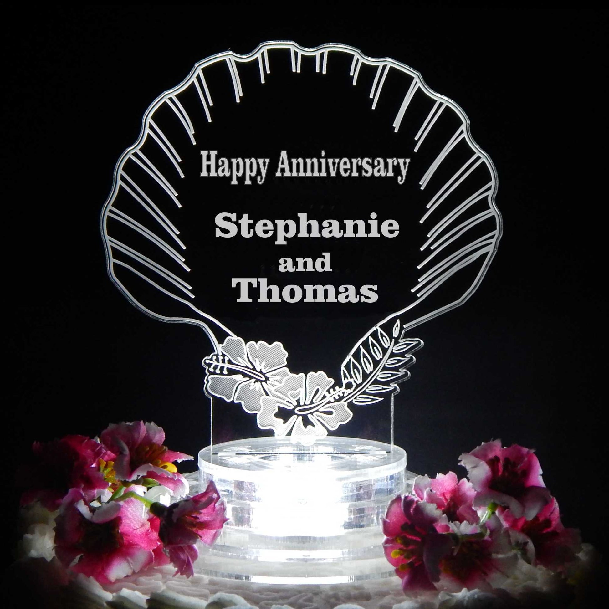 Clear acrylic cake topper design with seashell shape and engraved with names and Happy Anniversary
