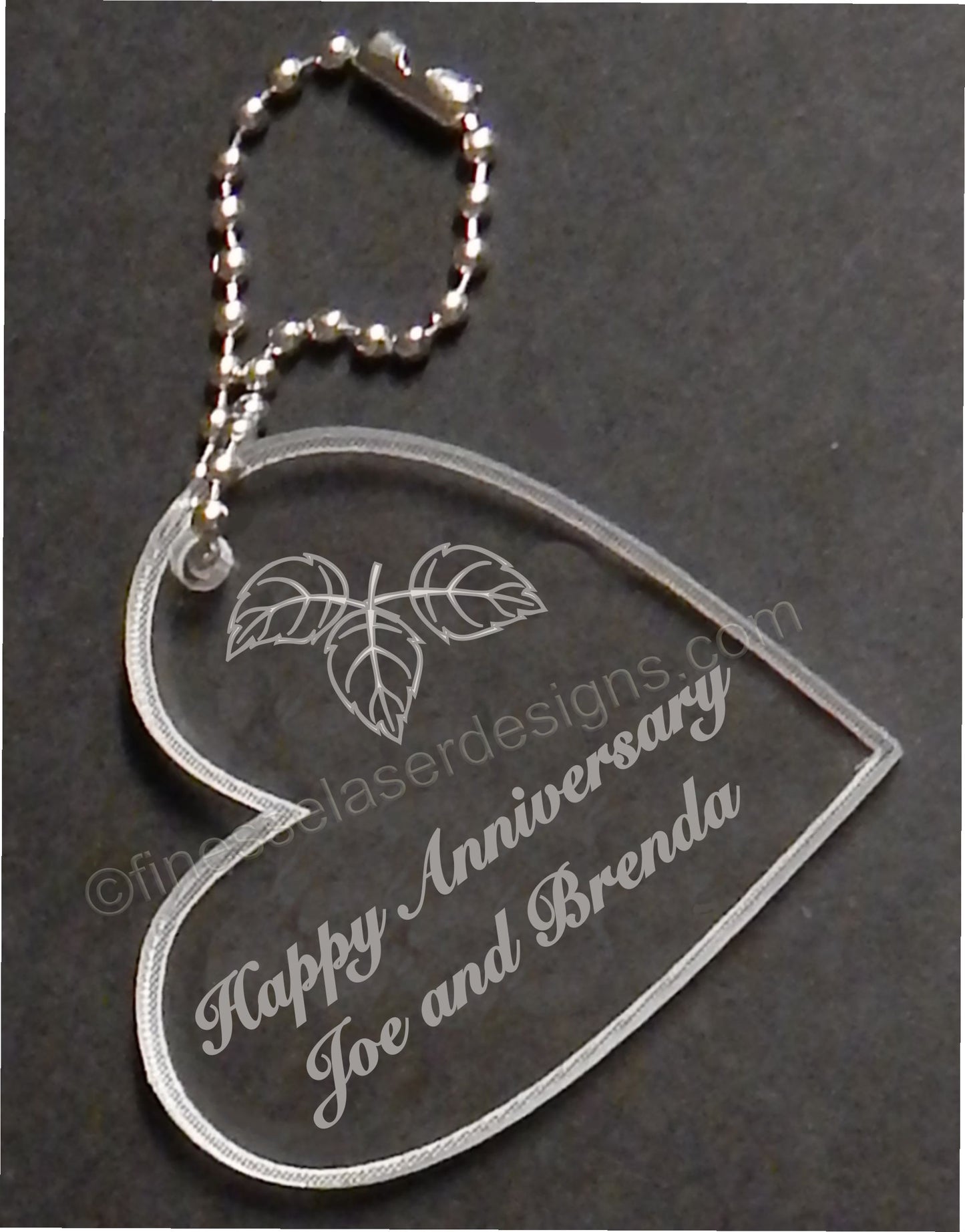 heart shaped keychain favor designed with fall leaves and engraved with Happy Anniversary and names, with small metal chain attached
