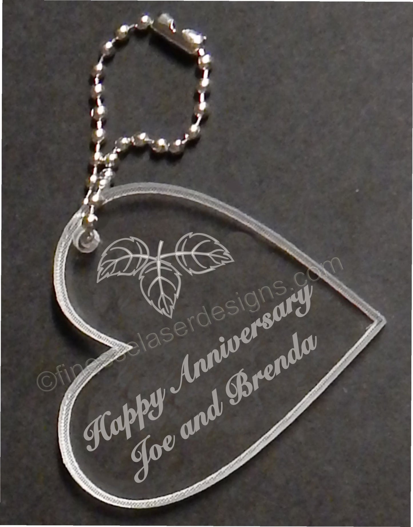 heart shaped keychain favor designed with fall leaves and engraved with Happy Anniversary and names, with small metal chain attached
