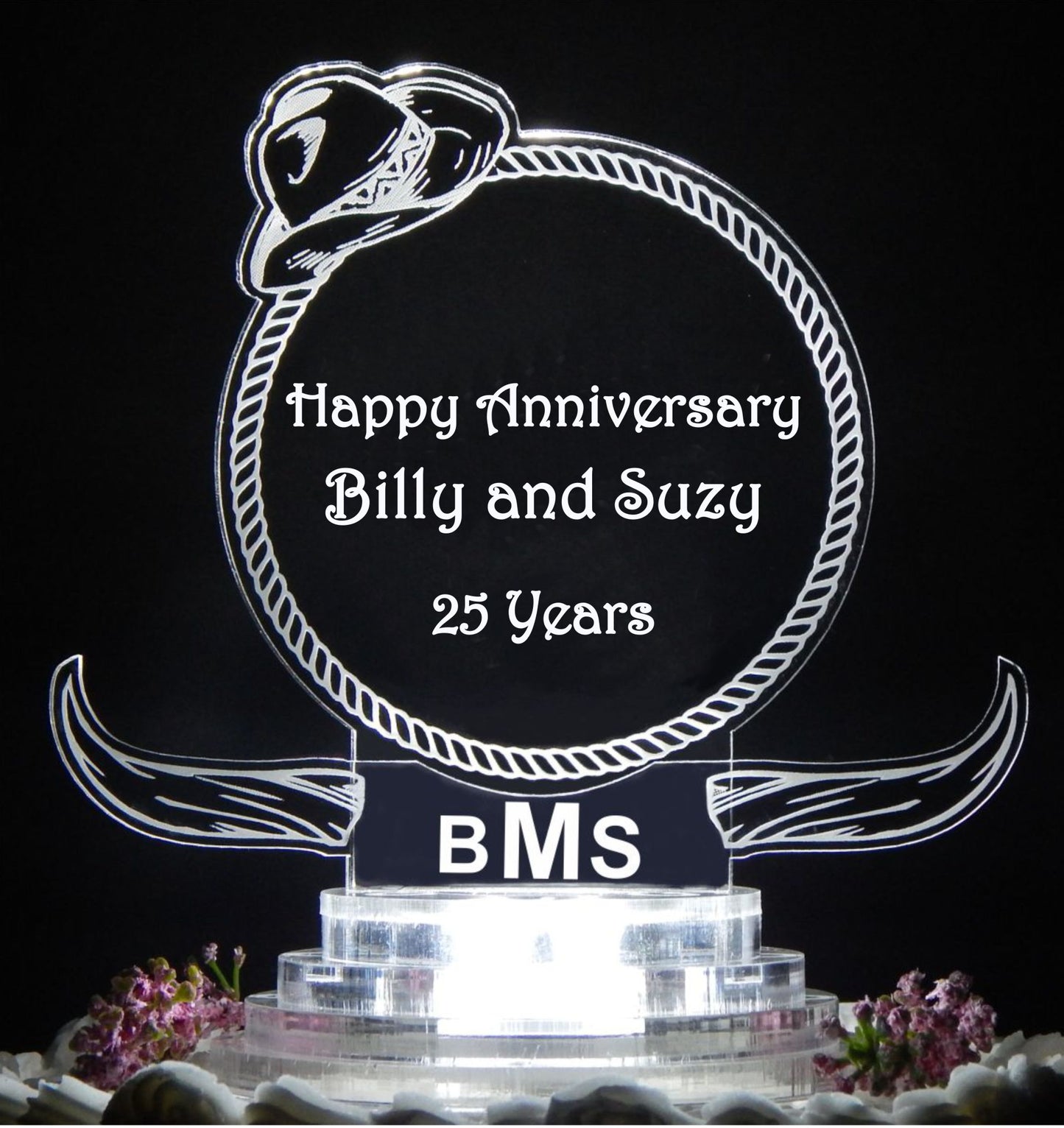 clear acrylic cake topper designed in a western cowboy theme with steer horns and cowboy hat, engraved with names and Happy Anniversary