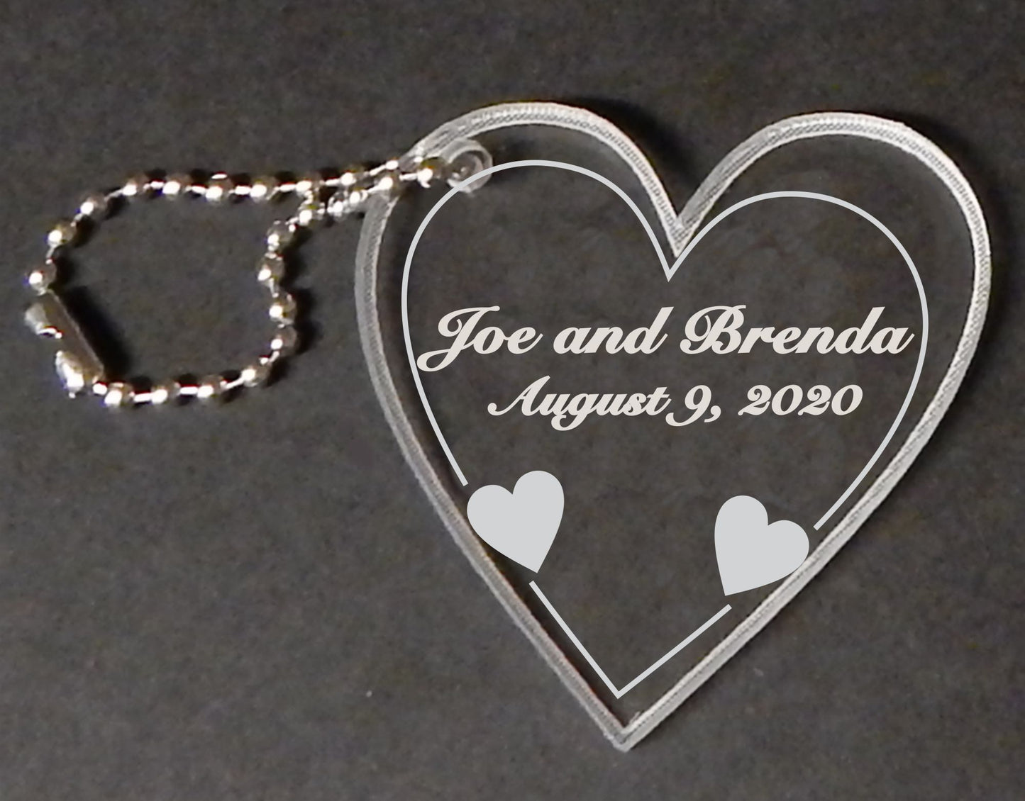 heart shaped acrylic keychain favor with names and date engraved, with attached metal chain