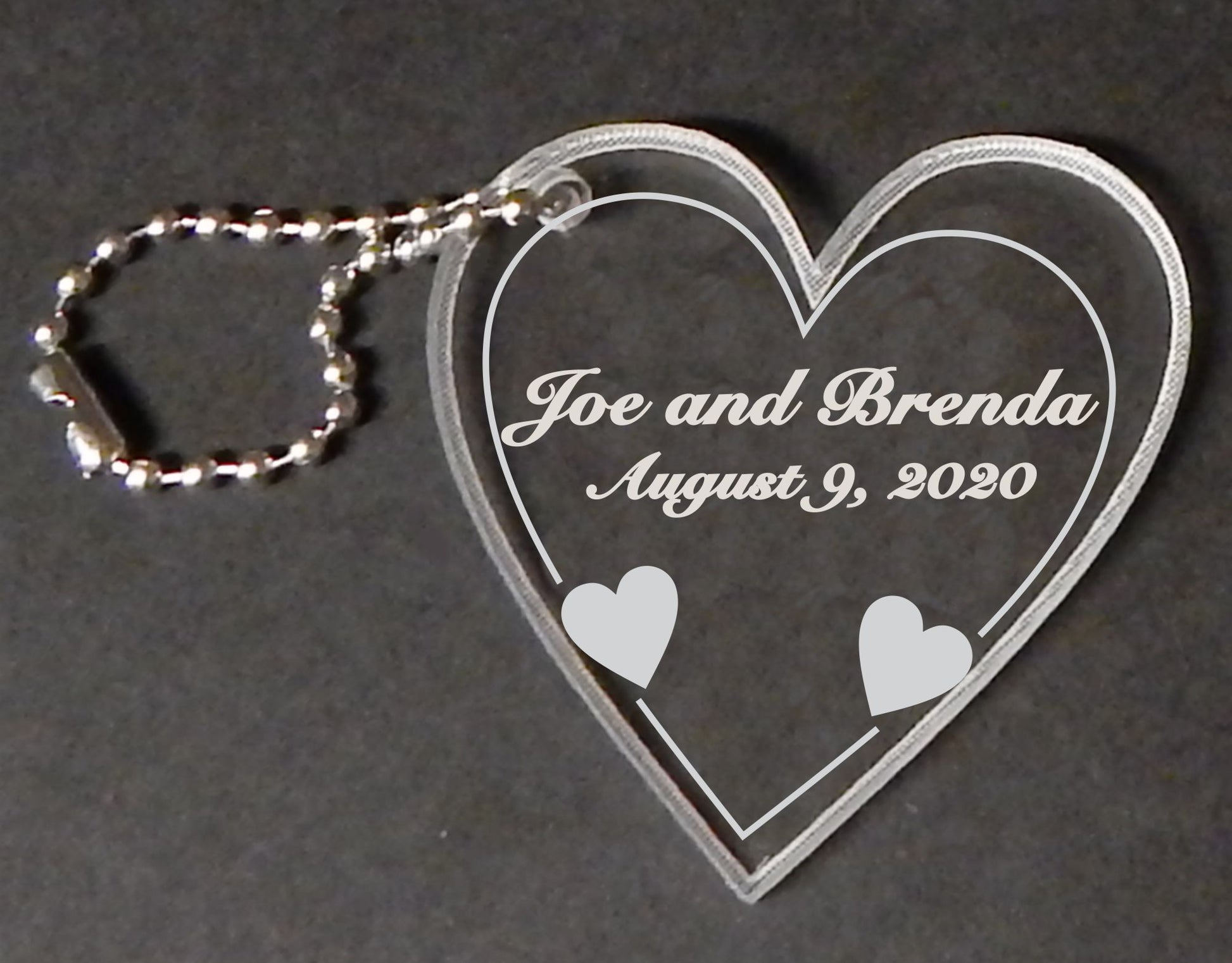heart shaped acrylic keychain favor with names and date engraved, with attached metal chain