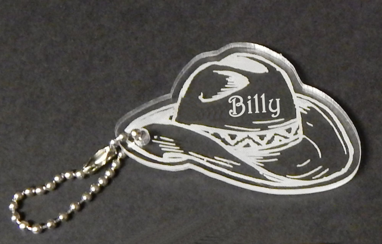 acrylic cowboy hat shaped keychain favor engraved with name and attached to a small chain