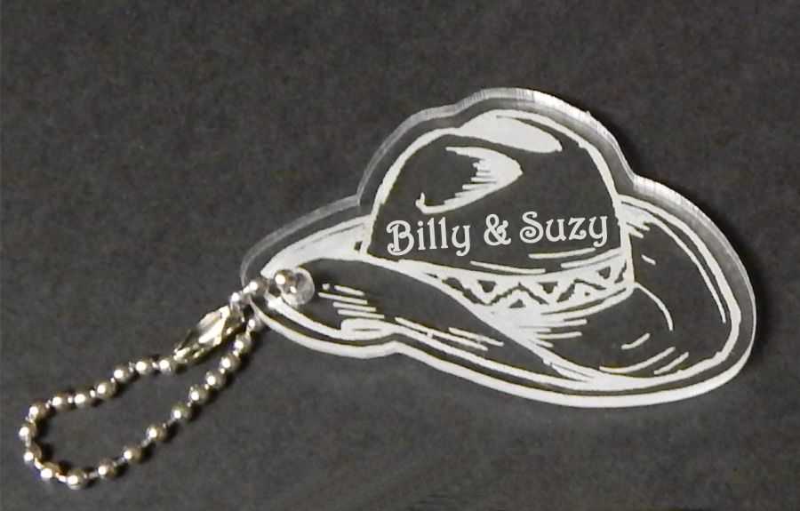 acrylic cowboy hat shaped keychain favor engraved with names and attached to a small chain