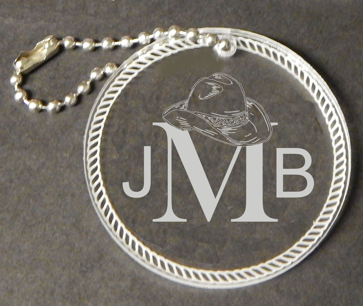 acrylic western round keychain favor engraved with monogram and attached to a small chain