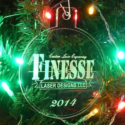 acrylic round ornament with business logo and year on a lit Christmas tree
