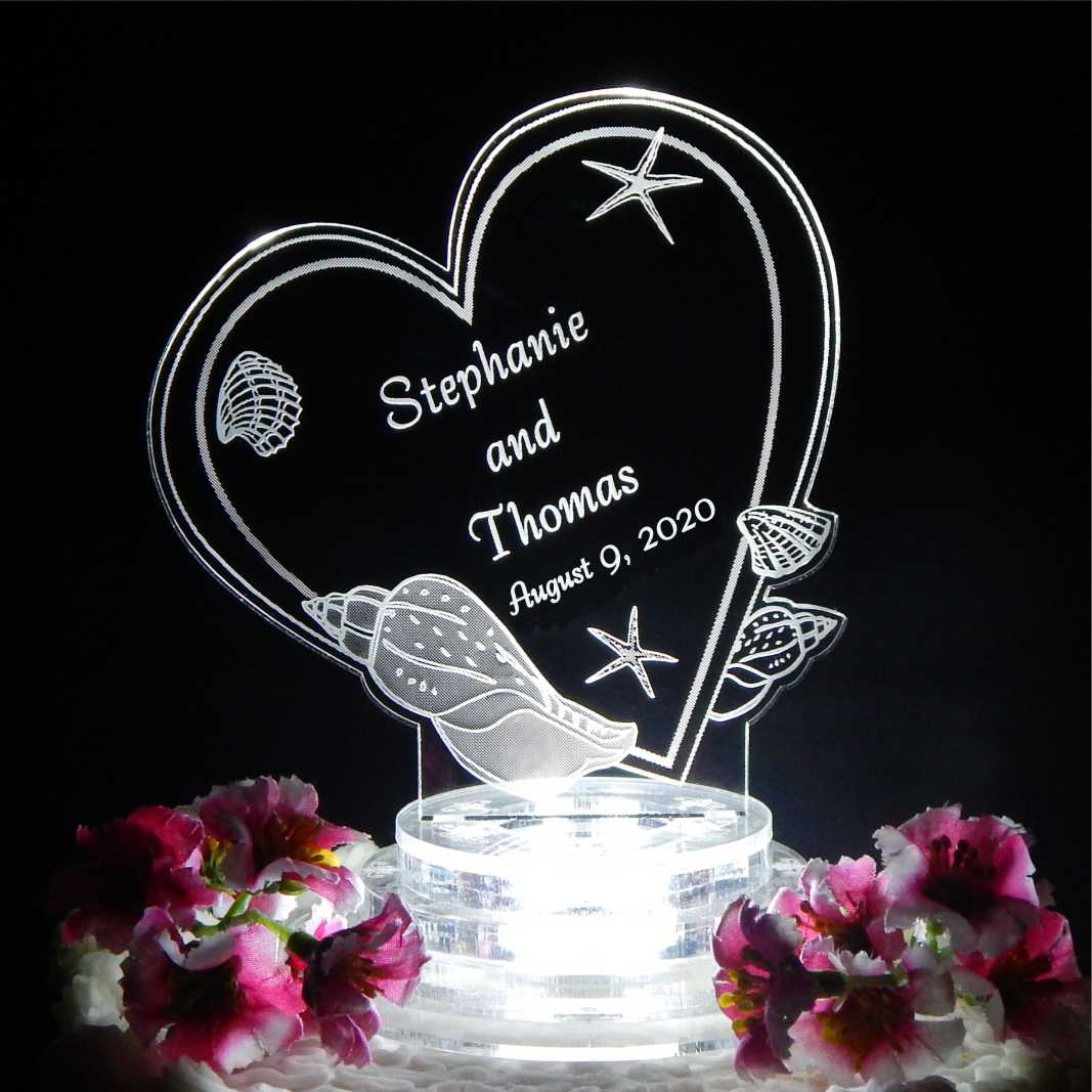 tilted heart shaped cake topper designed with seashells along with name and date engraved