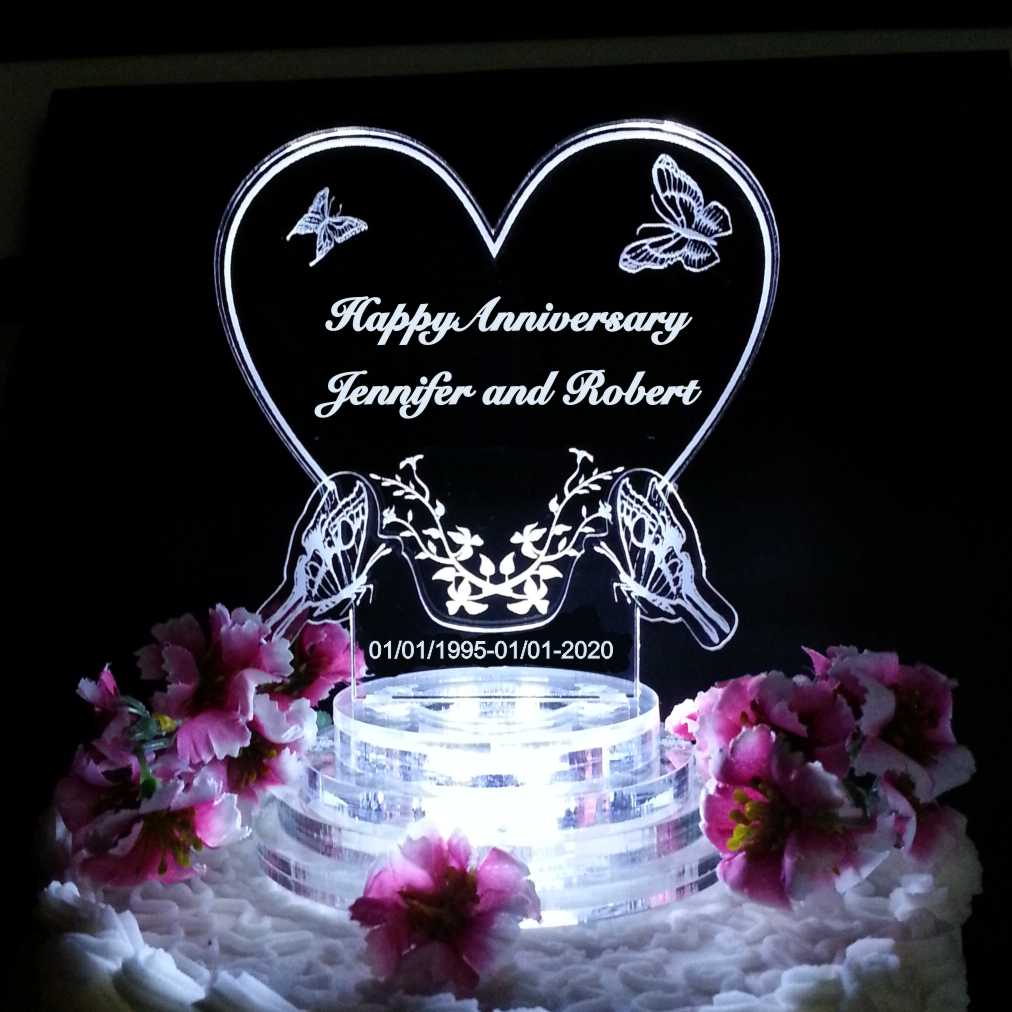 acrylic heart shaped cake topper with butterflies engraved along with Happy Anniversary and names
