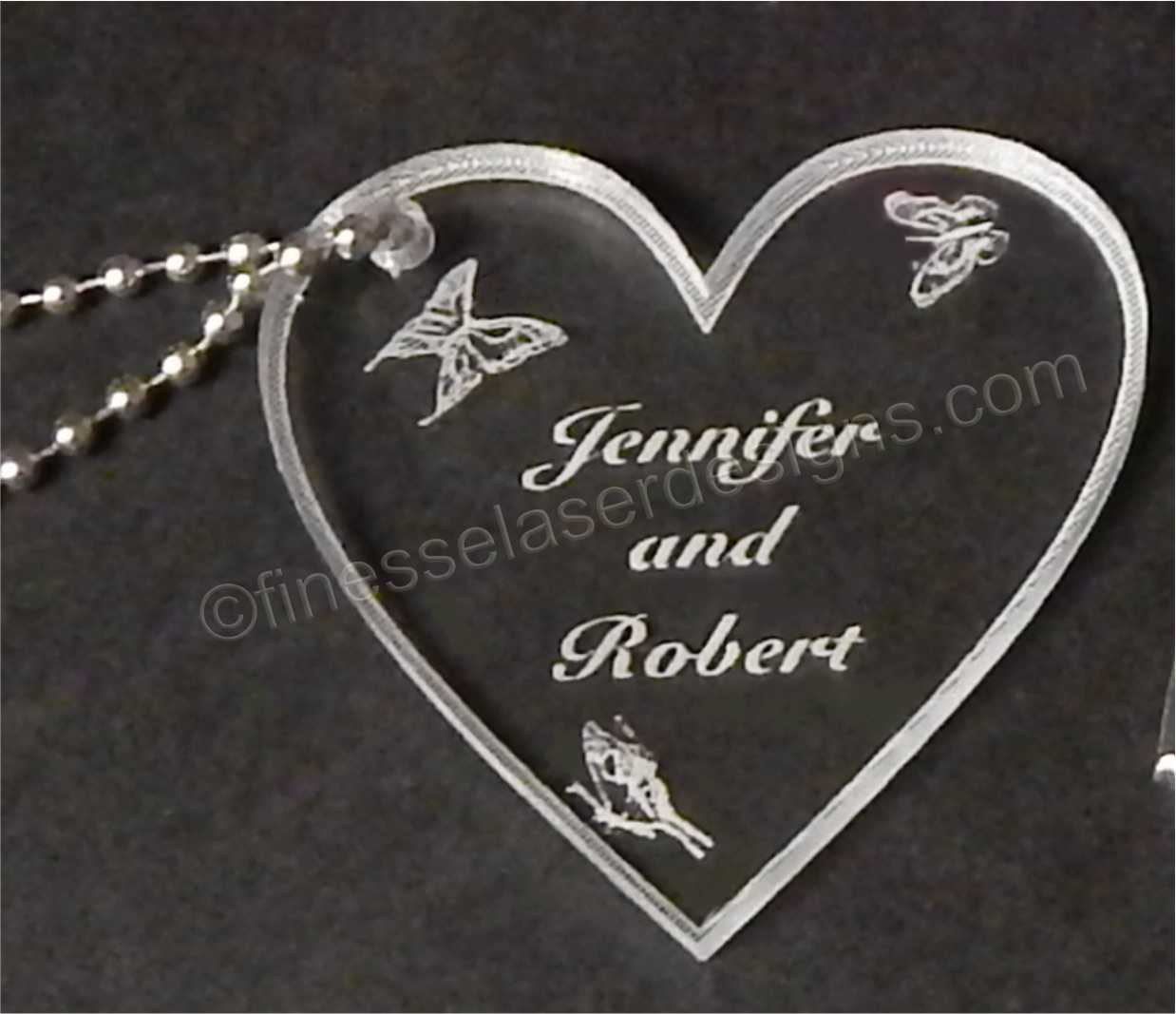 acrylic heart shaped keychain with butterflied and names engraved along with small metal chain attached