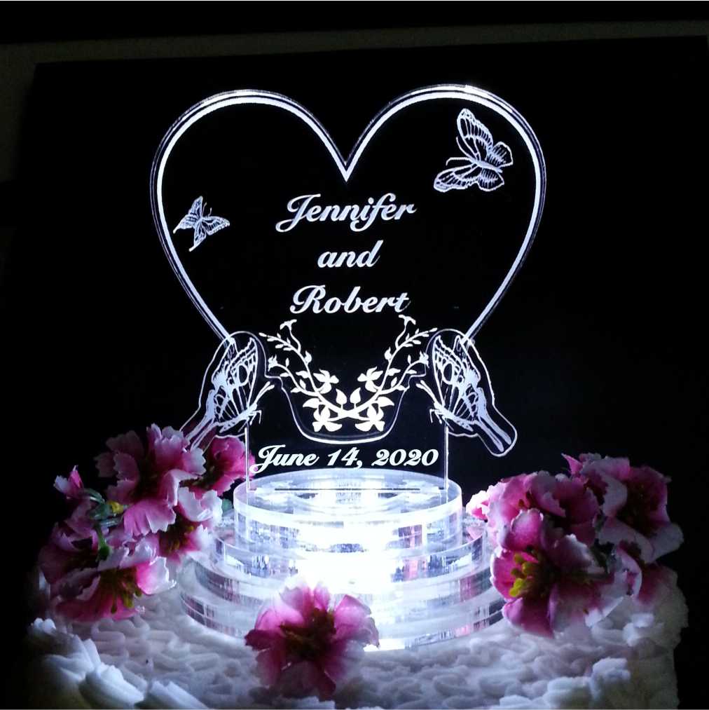acrylic heart shaped cake topper with butterflies engraved along with names and date of wedding