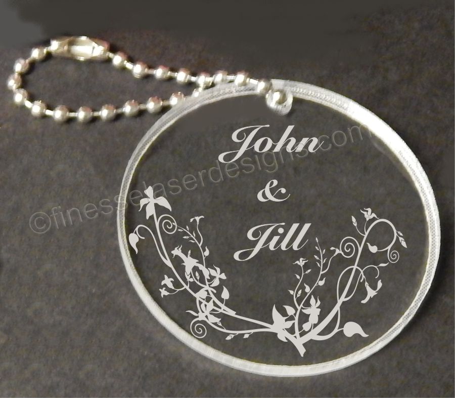 acrylic round shaped keychain with butterflied and names engraved along with small metal chain attached