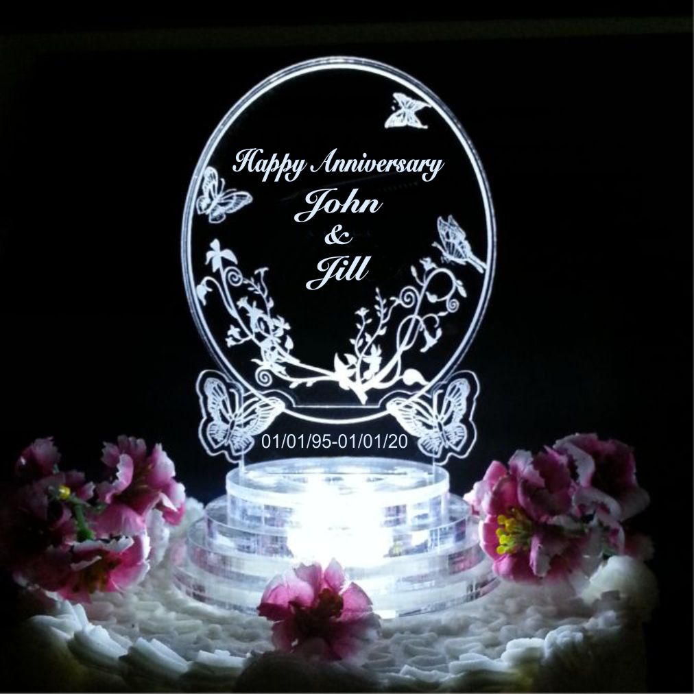 acrylic oval shaped cake topper with butterflies engraved along with Happy Anniversary and names