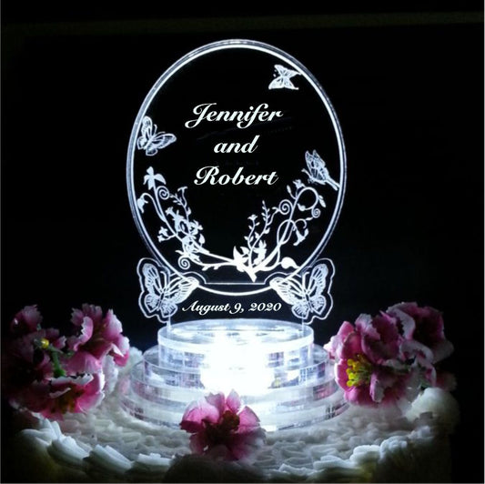 acrylic oval shaped cake topper with butterflies engraved along with names and date of wedding