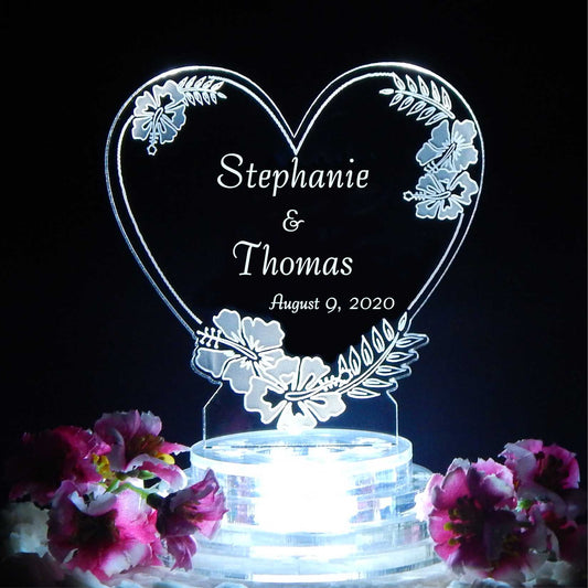 heart shaped acrylic cake topper with an hibiscus flower design and engraved with names and date