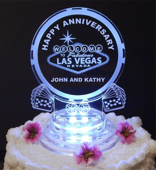 Lighted acrylic cake topper designed with a Welcome to Las Vegas sign, playing cards and dice, and Happy Anniversary, along with names