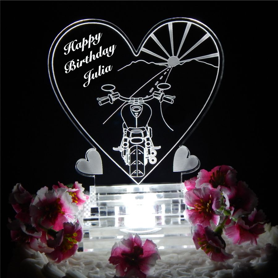 Acrylic heart shaped cake topper showing backside view of motorcycle driving towards sunset with Happy Birthday and name