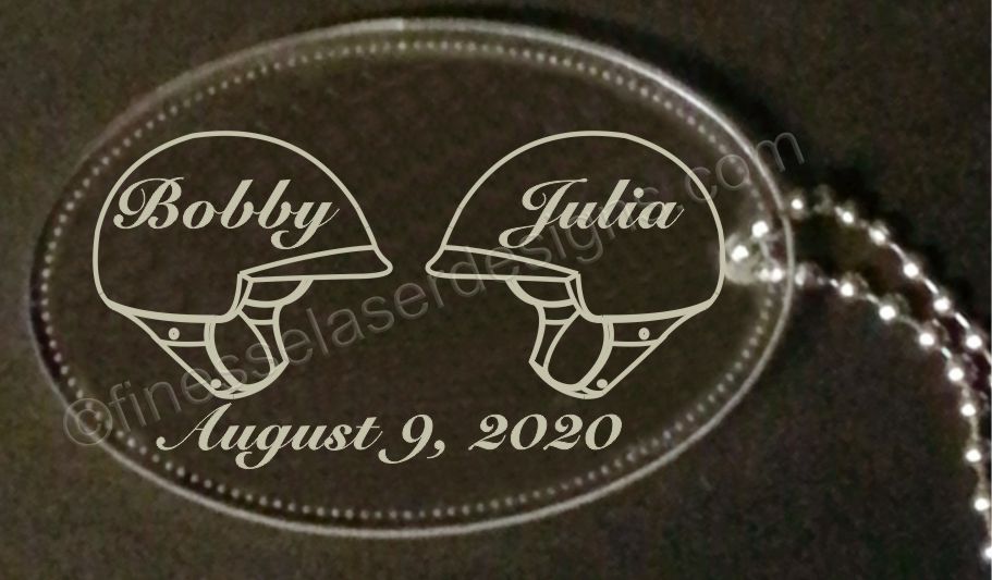 oval acrylic keychain with two helmets and names and date engraved