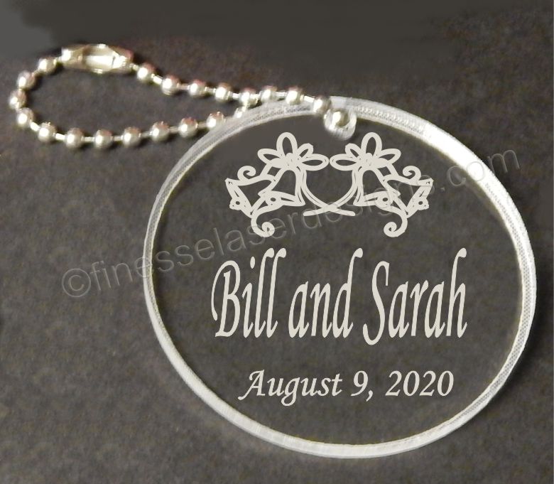 round acrylic keychain designed with wedding bells and names along with date, with attached metal chain