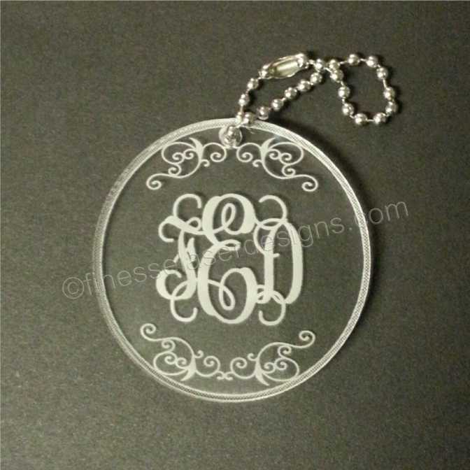 round acrylic keychain designed with a monogram and includes a small metal chain