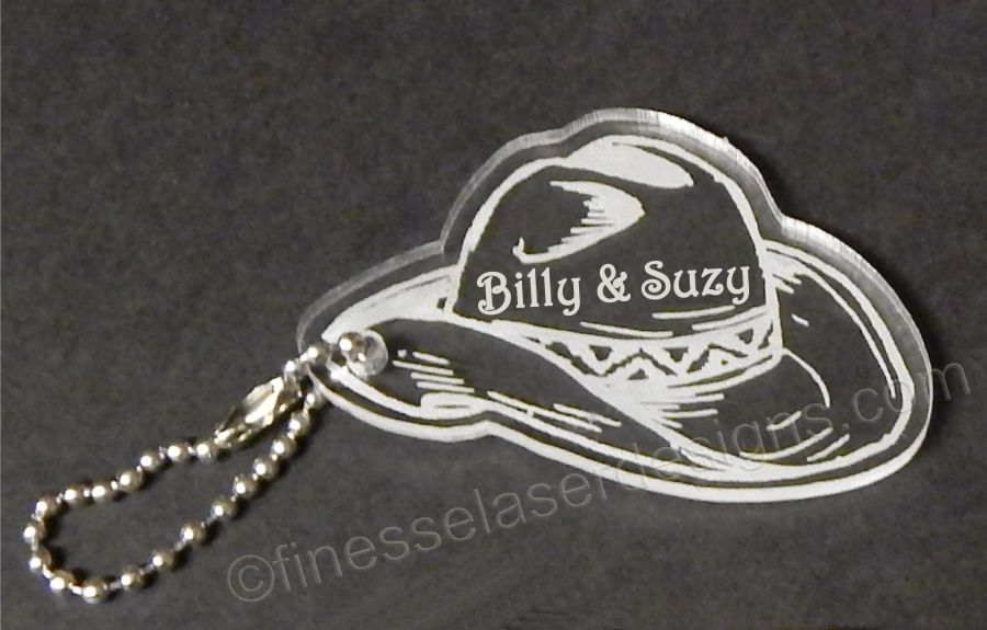 cowboy hat shaped acrylic keychain with names and a small metal chain attached